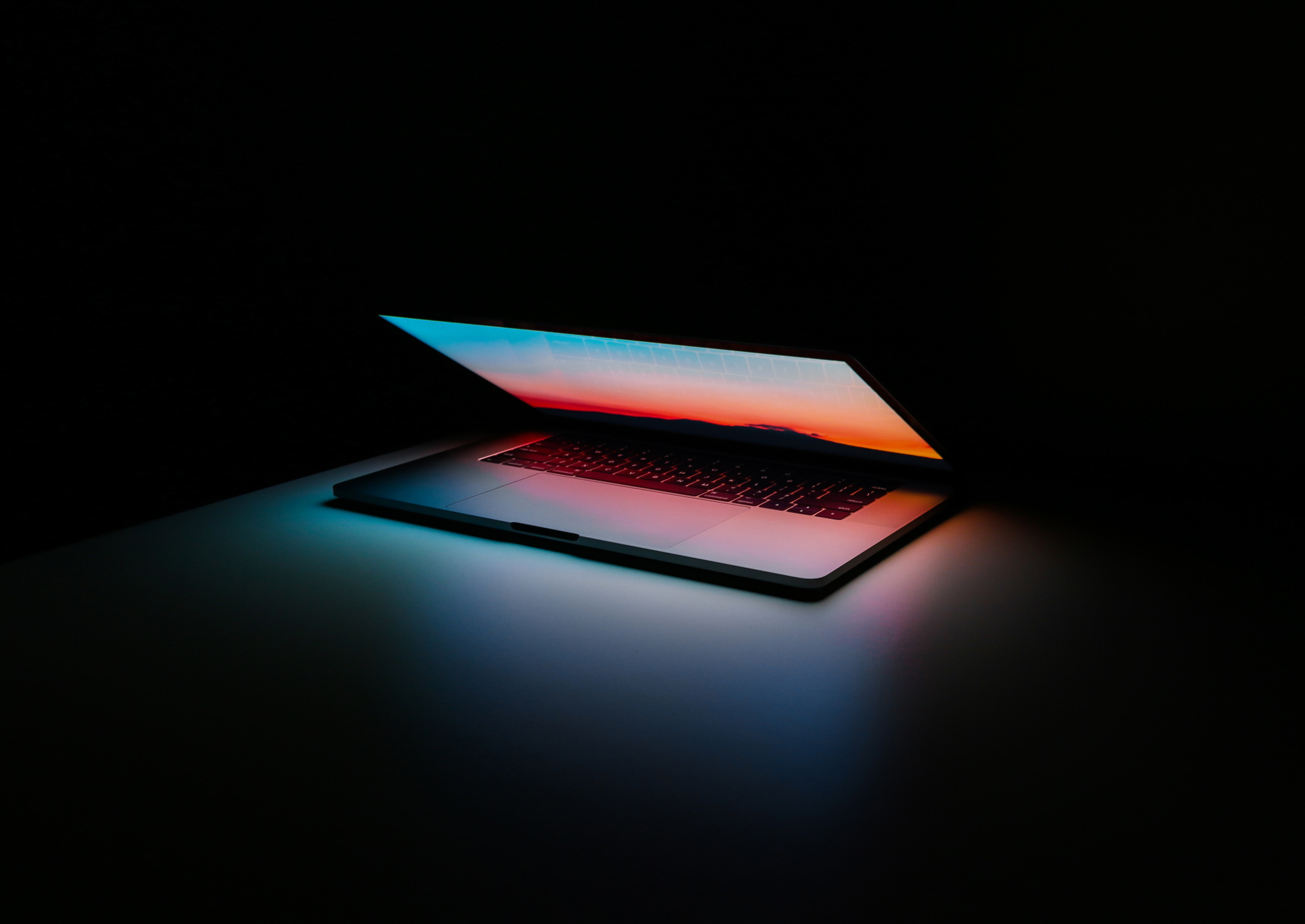Shadowy photo of a grey MacBook Air in the dark